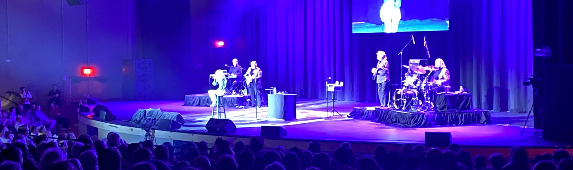 signer on stage in chair washed out by the lights Bloomington